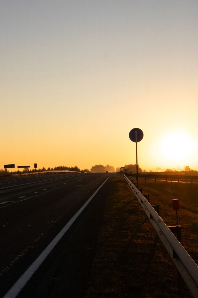 Soft-focus empty arterial at dawn, representing California bicycle and semitruck crash claim education without showing a collision.