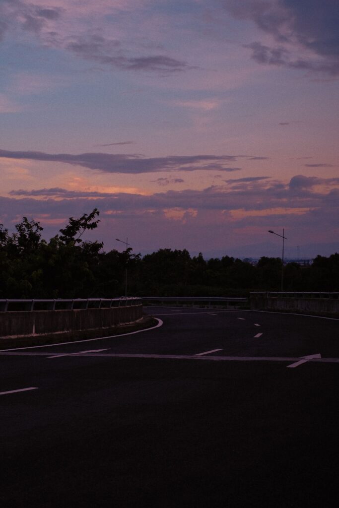 Quiet multi-lane city street at dusk, representing California e-bike traffic-lane crash education without showing a collision.