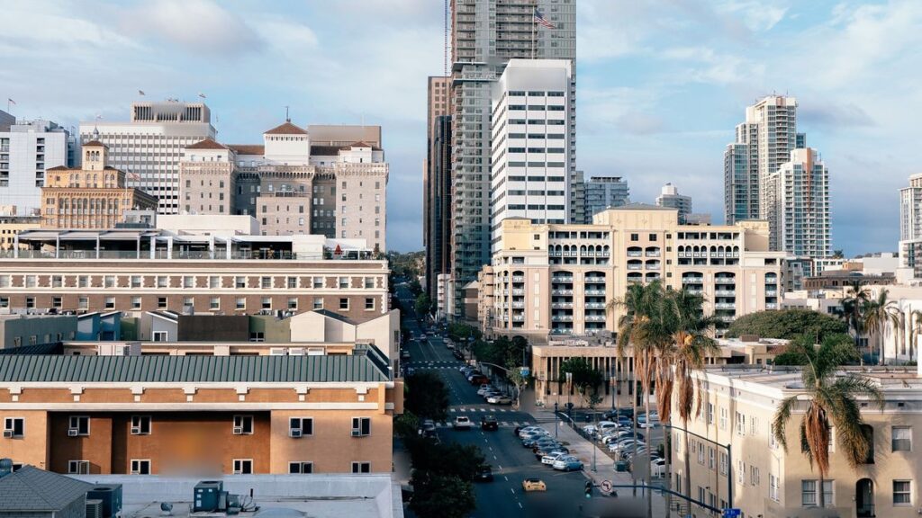 A downtown San Diego street lined with palm trees and buildings, seen from above. Photo by Ikaia Pal via Pexels, Pexels License (https://www.pexels.com/license/).